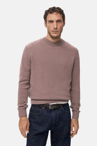 T-shirt rose avec col rond de MANGO, vu de derrière, associé à des jeans foncés et des chaussures noires.