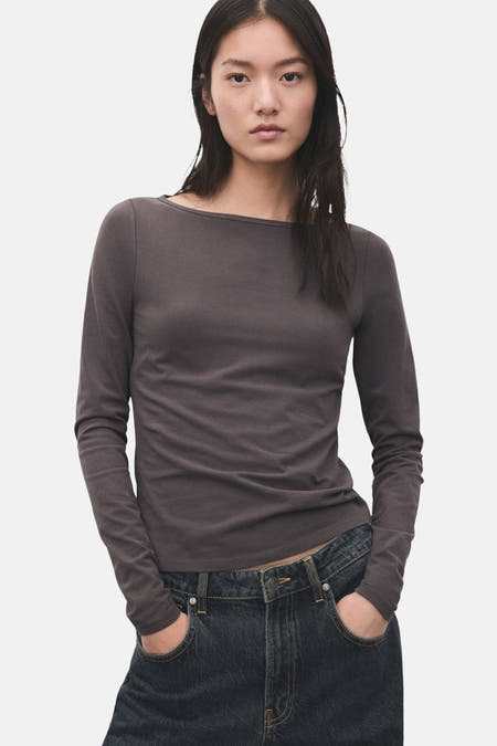Grijs T-shirt met lange mouwen van MANGO, met een boot halslijn en gedragen met een donkere jeans.
