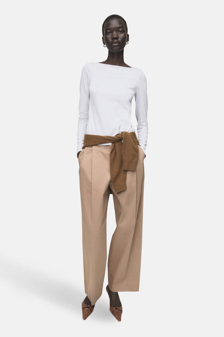 T-shirt bleu à manches longues de MANGO, porté avec un pantalon marron et une écharpe.