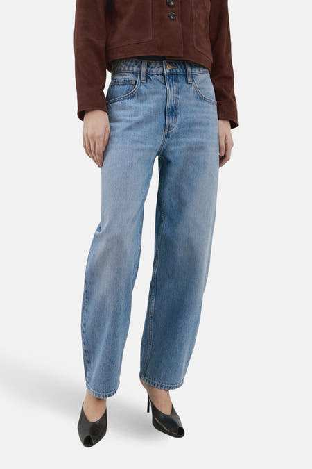 Jeans special fit van lichtblauw denim van MANGO, met wijde pijpen en gecombineerd met bruin jack en zwarte pumps.
