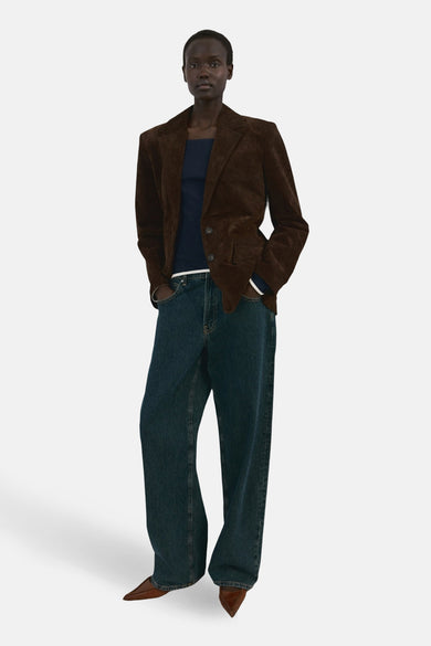 T-shirt bleu à manches longues de MANGO, porté avec une veste marron et un jean ample.