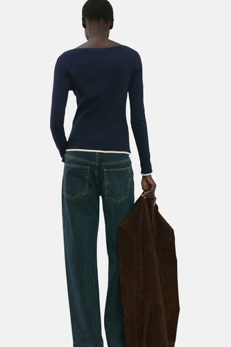 T-shirt bleu à manches longues de MANGO, vu de dos, associé à un jean et une veste marron.