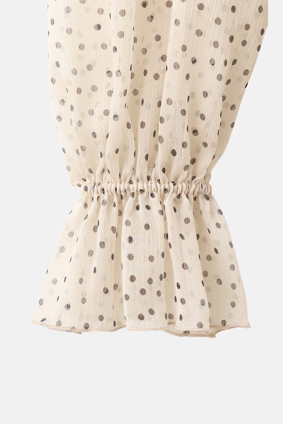 Chemisier beige de MANGO, avec des pois noirs et des poignets élastiques.