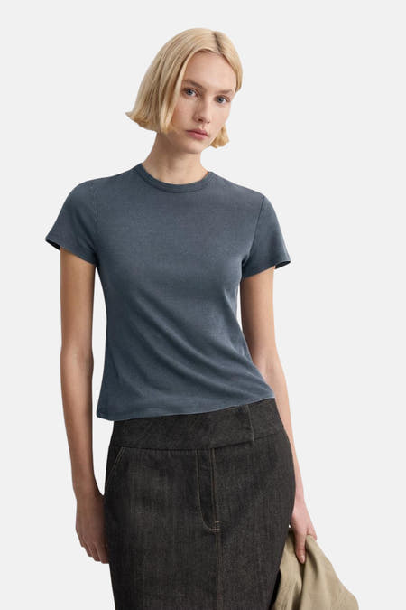 Haut bleue de MANGO, vue de dos, combinée avec un pantalon foncé.