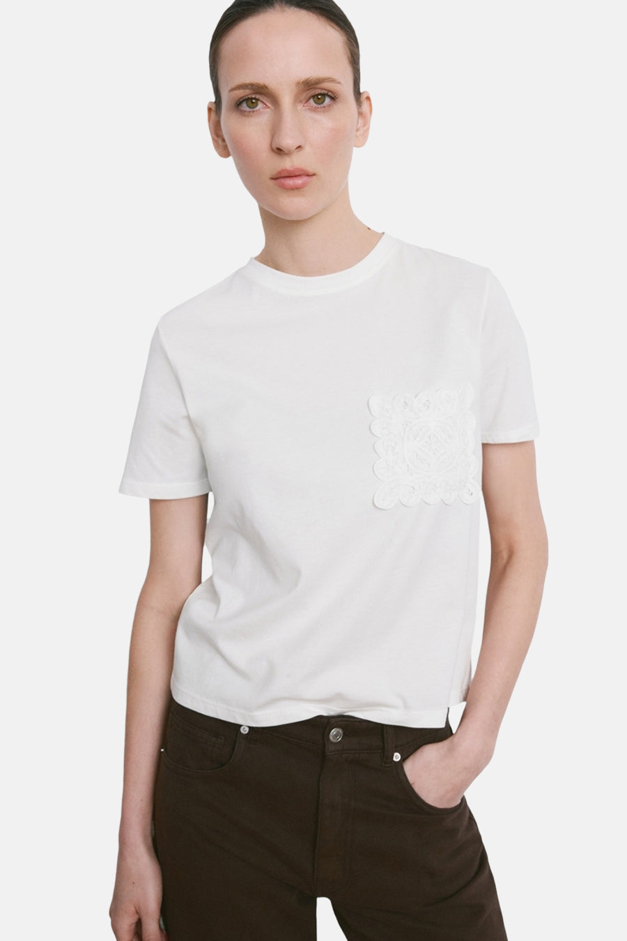 T-shirt blanc de MANGO, vu de dos, combiné avec un pantalon ample marron foncé.