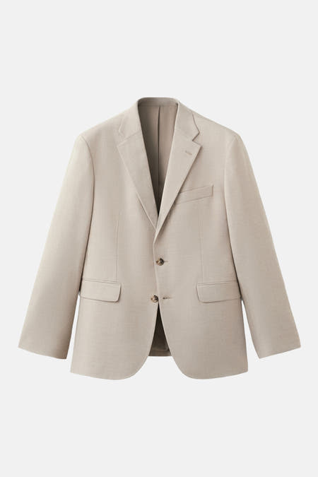 Beige blazer van MANGO, met revers en zakken aan de voorkant.
