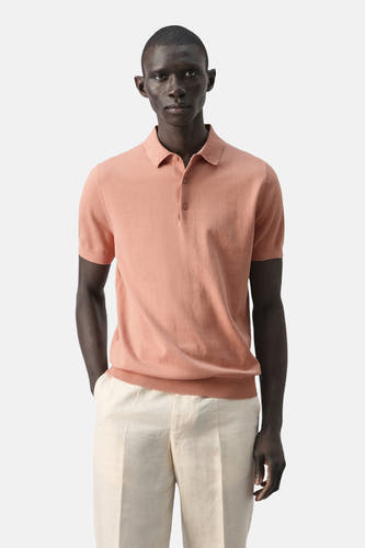 Polo orange de MANGO, vue arrière, combinée avec un pantalon clair.