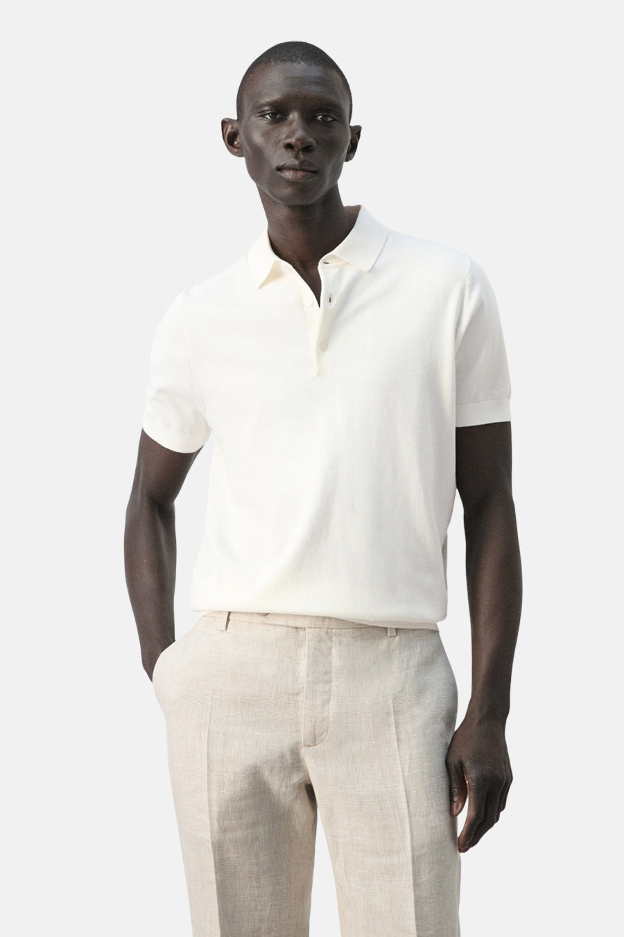Polo blanche de MANGO, vue de dos, portée avec un pantalon en lin.