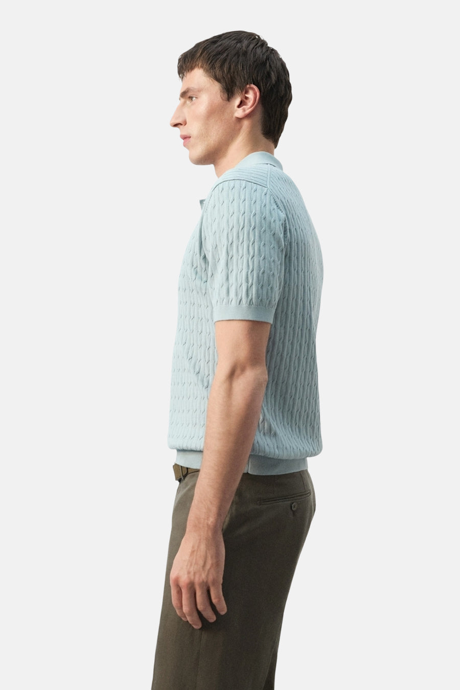 Polo bleu MANGO à motif torsadé et manches courtes, vue de profil, associée à un pantalon vert olive.