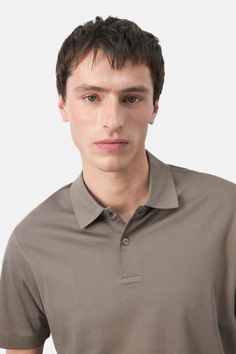 Polo marron de MANGO, gros plan d'un homme portant un polo taupe à manches courtes.