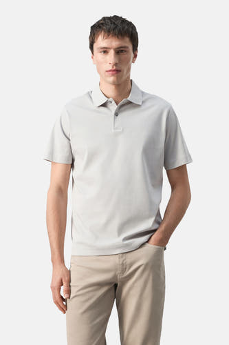 Polo grise de MANGO, vue de dos, à manches courtes et associée à un pantalon beige.