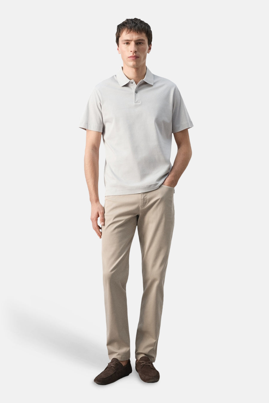 Polo grise de MANGO, portée avec un pantalon kaki et des mocassins marron, présentée debout.