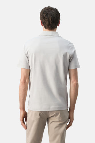 Grijs poloshirt van MANGO, gezien van achteren, met korte mouwen en gecombineerd met beige broek.