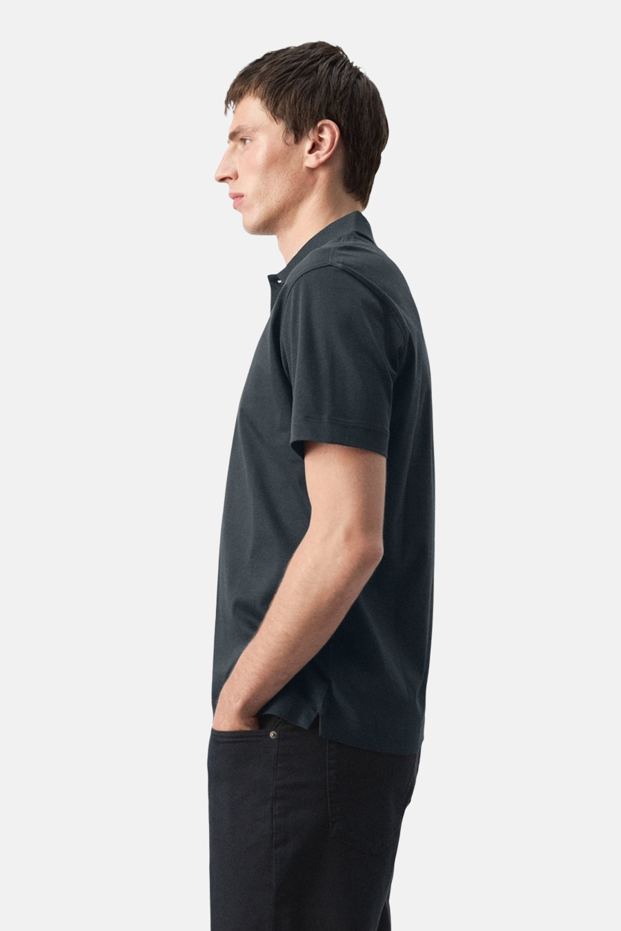 Polo bleu de MANGO, portée de profil avec un pantalon foncé.