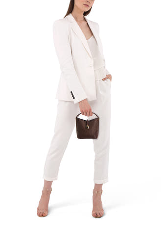 Sac à main marron de MANGO avec texture tissée et fermoir doré, porté par un mannequin dans un tailleur blanc.