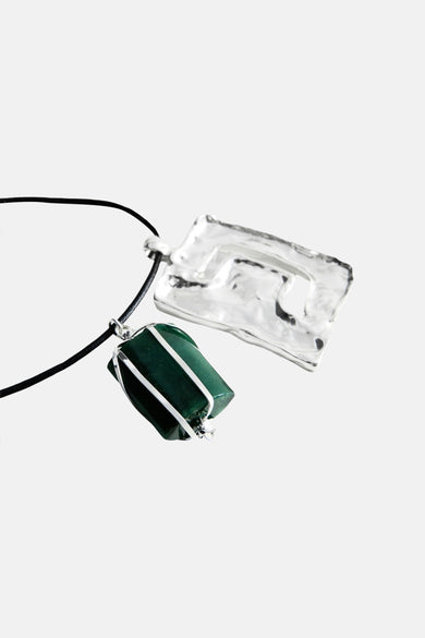 Collier court multicolore de MANGO, avec pierre verte dans un fil argenté et pendentif martelé argenté sur cordon noir.