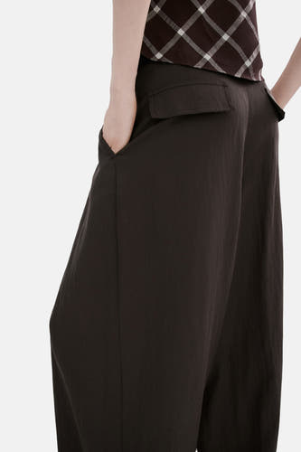 Pantalon marron de MANGO, avec une coupe ample et des poches, combiné avec un haut à carreaux.