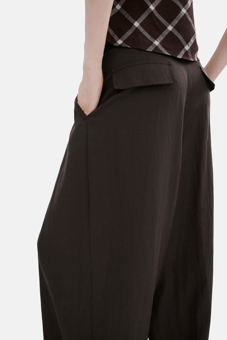 Pantalon marron de MANGO, avec une coupe ample et des poches, combiné avec un haut à carreaux.