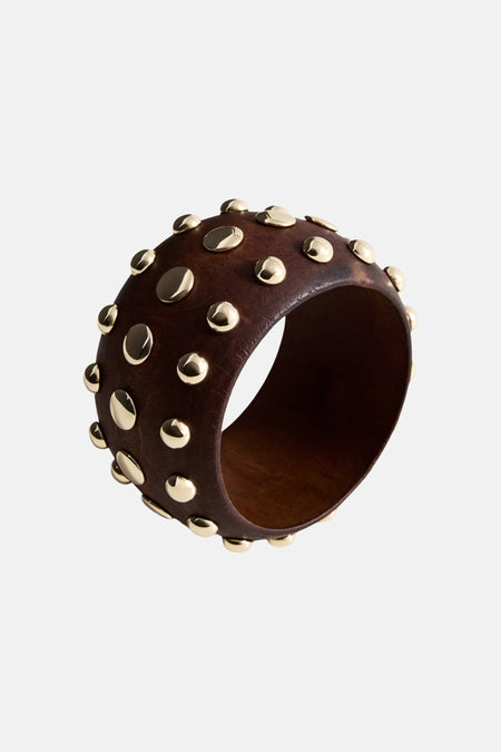 Bracelet marron de MANGO, orné de clous métalliques dorés sur toute la surface.