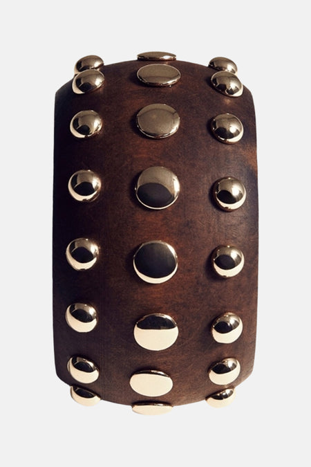 Bruine armband van MANGO, versierd met glanzende, goudkleurige studs in rijen geplaatst.