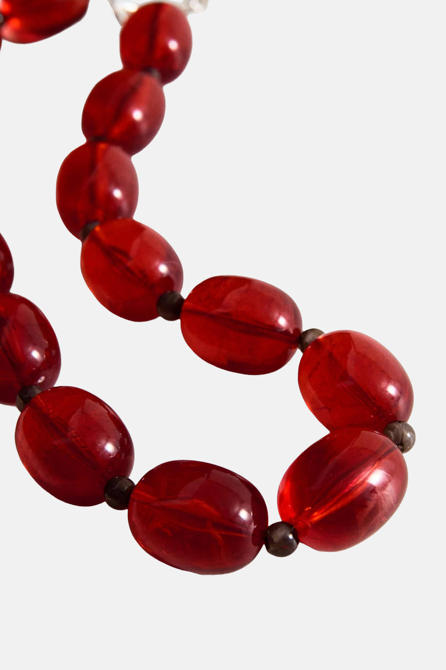 Collier court rouge de MANGO avec perles ovales transparentes brillantes et petites perles intercalaires foncées.