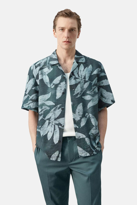 Chemise structurée à manches courtes de couleur vert foncé avec motif à feuilles bleu clair de MANGO, vue de dos sur un homme.