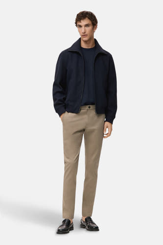Beige chino de MANGO, porté avec un manteau bleu marine et des chaussures en cuir noires.