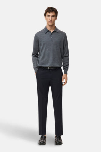 Jean bleu de MANGO, associé à une polo grise et des chaussures en cuir noires.