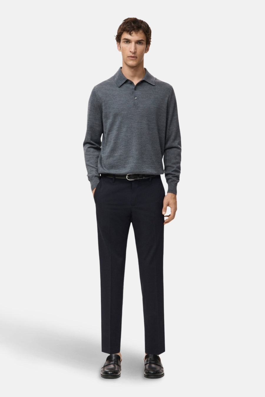Jean bleu de MANGO, associé à une polo grise et des chaussures en cuir noires.