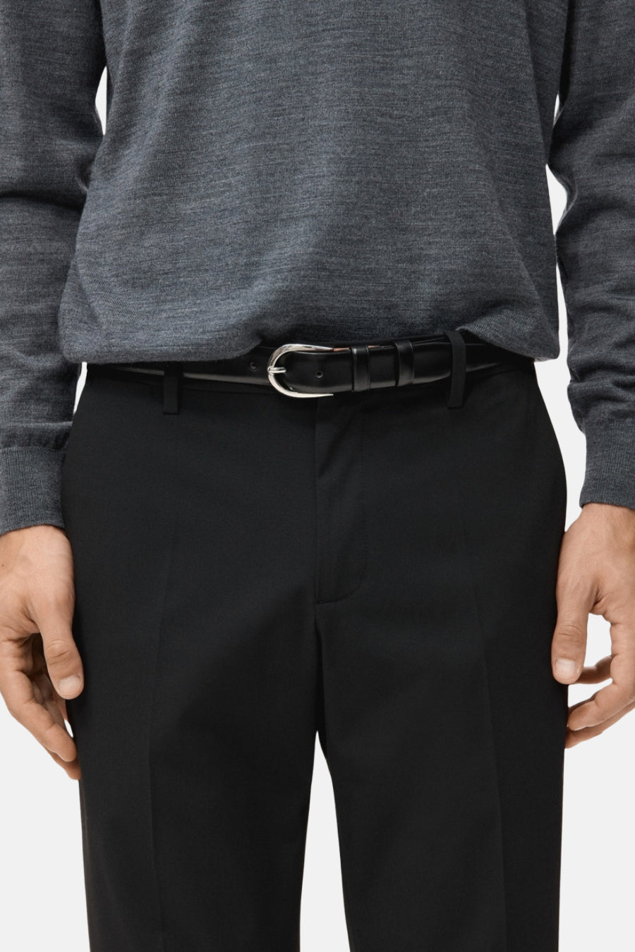 Chino noir de MANGO, associé à une chemise grise et un ceinture noire avec boucle argentée.