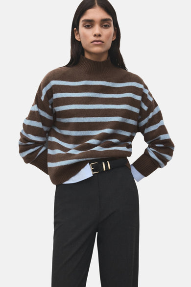 Sweat-shirt multicolore à col rond de MANGO, avec des rayures brunes et bleu clair, associé à un pantalon noir.