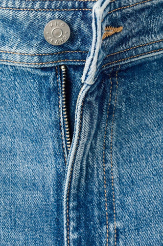 Jean en denim bleu moyen de MANGO, avec une fermeture à glissière et un détail de bouton.