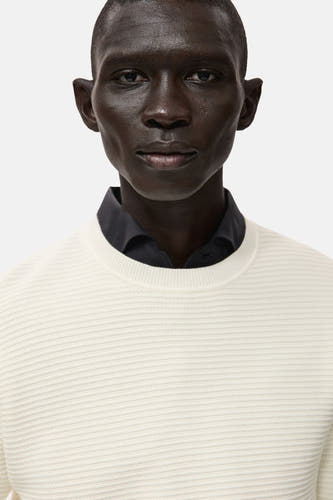 T-shirt écru avec col rond de MANGO, gros plan avec un chemisier noir en dessous.