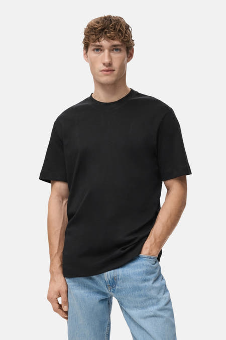 T-shirt noir à manches courtes de MANGO, avec modèle en jeans bleu clair, vue arrière.