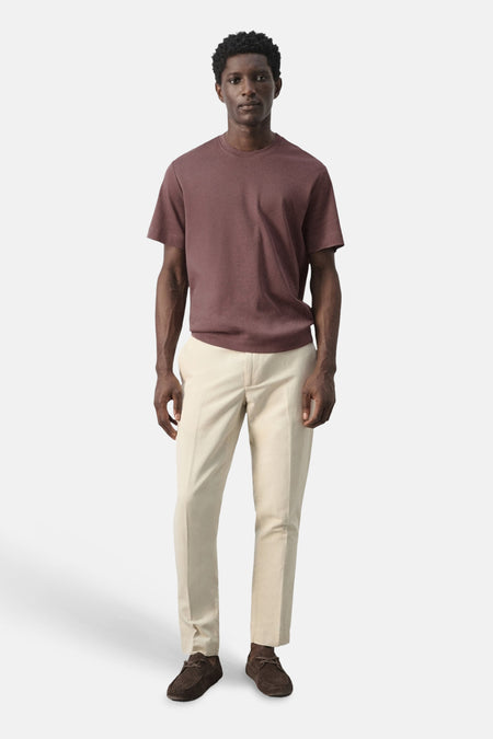 T-shirt marron à manches courtes de MANGO, combiné avec un pantalon beige et des chaussures marron.