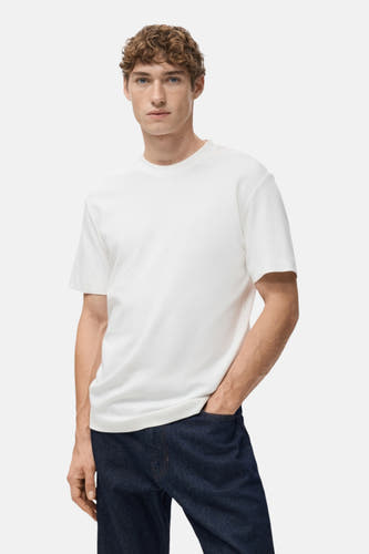 T-shirt blanc à manches courtes de MANGO, vu de dos, porté avec des jeans bleus foncés.
