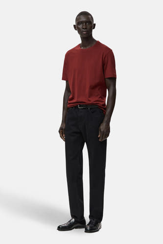 T-shirt rouge à manches courtes de MANGO, porté avec des jeans noirs et des loafers en cuir.