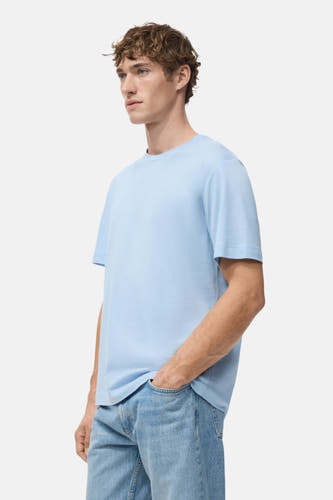 T-shirt bleu à manches courtes de MANGO, porté avec un jean bleu, en vue latérale.