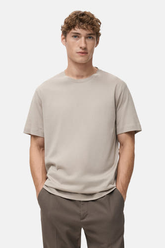 T-shirt beige à manches courtes de MANGO, vu de derrière, associé à un pantalon marron.