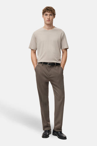 T-shirt beige à manches courtes de MANGO, porté avec un pantalon marron et une ceinture en cuir noir.
