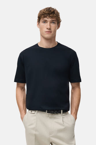 T-shirt bleu à manches courtes de MANGO, vue arrière avec un pantalon beige.