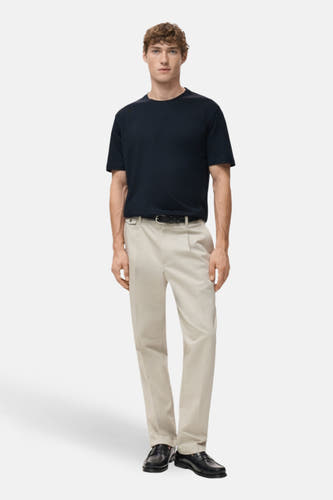 T-shirt bleu à manches courtes de MANGO, porté avec un pantalon beige, une ceinture et des chaussures noires.