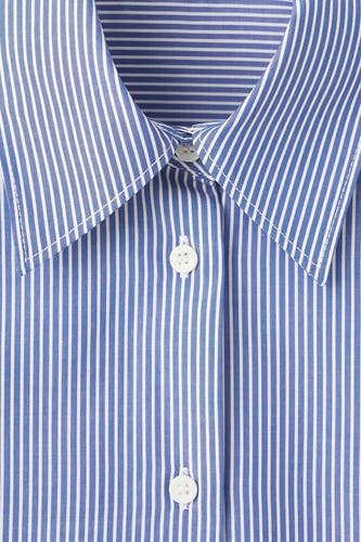 Chemise bleue rayée à manches longues de MANGO, avec col classique et fermeture à boutons.
