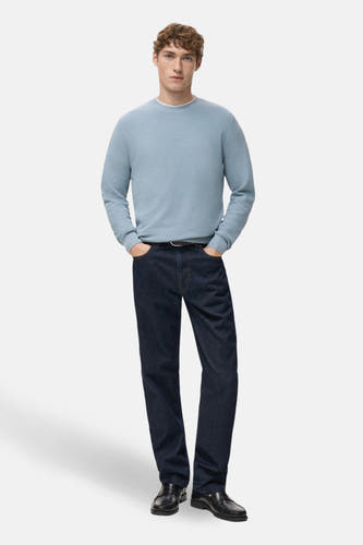 T-shirt bleu avec col rond de MANGO, porté avec des jeans foncés et des loafers en cuir.