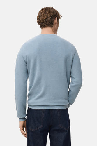 Blauwe trui met ronde hals van MANGO, gezien van achteren, gecombineerd met donkere jeans.
