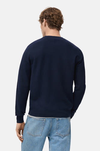 Blauwe trui met ronde hals van MANGO, gezien van achteren, gecombineerd met een lichte jeans.