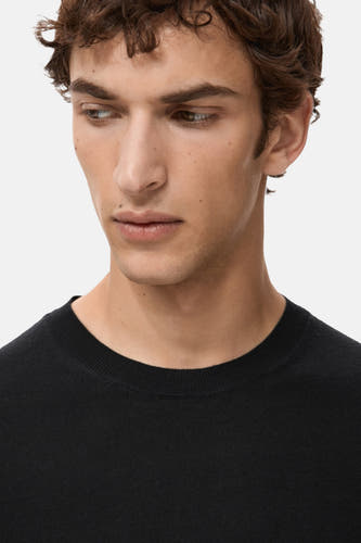 Sweat-shirt noir à col rond de MANGO, gros plan du col et du visage du modèle.