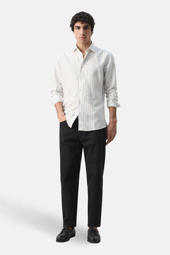 Chemise multicolore à manches longues de MANGO, à rayures verticales et portée avec un jean noir et des chaussures.