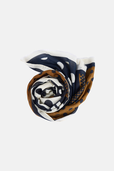 Écharpe d'été multicolore de MANGO, avec un motif à pois blanc, bleu marine et marron, roulée.