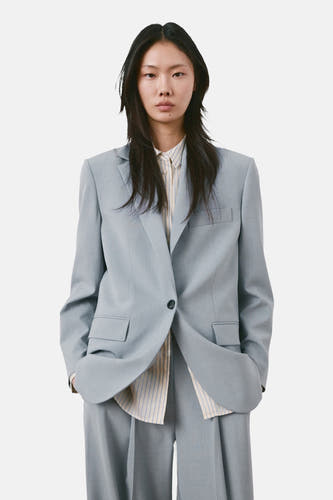 Blazer bleue de MANGO, vue de dos, avec col à revers et poches passepoilées.